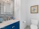 A stylish bathroom with a square mirror, blue vanity and tiled backsplash, and matching framed art at 2733 E Virginia St, Gilbert, AZ 85296