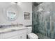 A bathroom featuring stone-look accent wall, a modern shower, and a stylish round mirror above the sink at 2733 E Virginia St, Gilbert, AZ 85296