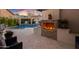 Cozy outdoor patio area featuring a brick fireplace and views of a luxurious pool at 2733 E Virginia St, Gilbert, AZ 85296