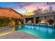 Backyard pool featuring a pergola, fire features, and ambient lighting, ideal for outdoor entertaining at 2733 E Virginia St, Gilbert, AZ 85296