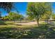 Sandy volleyball court ready for play, surrounded by lush green lawns and mature shade trees at 2733 E Virginia St, Gilbert, AZ 85296