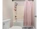 Bathroom with a shower and tub combination, white tile, and decorative pink shower curtain at 30427 W Vale Dr, Buckeye, AZ 85396