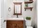 Bathroom vanity with dark wood cabinets, a mirror, decor, and a toilet at 30427 W Vale Dr, Buckeye, AZ 85396
