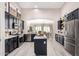 Open kitchen with black cabinets, stainless appliances, white countertops, and dining area views at 30427 W Vale Dr, Buckeye, AZ 85396