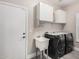 Laundry room with updated washer and dryer, sink, overhead storage, and exterior door at 30427 W Vale Dr, Buckeye, AZ 85396