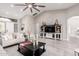 Spacious living room with vaulted ceiling, fan, wood-look floors, and modern entertainment center at 30427 W Vale Dr, Buckeye, AZ 85396