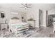Bright main bedroom showcases a ceiling fan, bench, and a view into the hallway at 30427 W Vale Dr, Buckeye, AZ 85396