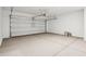 Spacious two car garage with automatic door and painted white walls at 40005 W Hillman Dr, Maricopa, AZ 85138