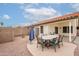 Backyard patio with a table and chairs, orange gravel landscaping, and a blue umbrella at 4032 E Arbor Ave, Mesa, AZ 85206