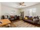 Cozy living room with a ceiling fan, desk, bookshelves, and a comfortable brown futon couch, perfect for relaxation at 4225 N 16Th Ave, Phoenix, AZ 85015