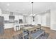 Bright kitchen with white cabinetry, stainless steel appliances and a large island and modern dining room table at 4370 E Kaibab Pl, Chandler, AZ 85249