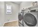 Functional laundry room with a stacked washer and dryer and a window with shutters at 4370 E Kaibab Pl, Chandler, AZ 85249
