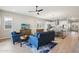 Open-concept living room with wood floors, ceiling fan and view into kitchen with white cabinets and stainless appliances at 4370 E Kaibab Pl, Chandler, AZ 85249