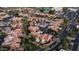 Bird's-eye view of a residential community with terracotta roofs, lush landscaping, and a pool and tennis courts in the background at 4434 E Camelback Rd # 128, Phoenix, AZ 85018