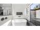 Modern bathroom with a soaking tub, sleek fixtures, and natural light from the exterior at 4434 E Camelback Rd # 128, Phoenix, AZ 85018