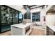Modern kitchen featuring a white island, pendant lighting, and floor-to-ceiling sliding glass doors to outdoor living space at 4434 E Camelback Rd # 128, Phoenix, AZ 85018