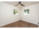Well-lit bedroom with sleek ceiling fan, two windows offering natural light, and hardwood floors, creating a serene space at 4721 N 24Th St, Phoenix, AZ 85016