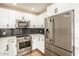 Kitchen featuring stainless steel appliances, white cabinets, modern hardware and a view of the dining area at 4721 N 24Th St, Phoenix, AZ 85016