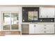 Modern kitchen featuring white cabinets, stainless steel appliances, and a dark backsplash with a view to the backyard at 4721 N 24Th St, Phoenix, AZ 85016