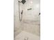 Elegant shower showcasing marble-style tiles, modern black fixtures, and a functional recessed shelf for toiletries at 4721 N 24Th St, Phoenix, AZ 85016