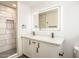 Modern bathroom with a double vanity, illuminated mirror, and a walk-in shower with tiled walls at 4729 N 24Th St, Phoenix, AZ 85016