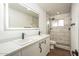 Modern bathroom featuring double sinks, quartz countertops, a large mirror and a tiled walk-in shower at 4729 N 24Th St, Phoenix, AZ 85016