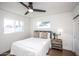 Bright bedroom showcasing a bed with neutral linens, a ceiling fan, and lots of natural light through dual windows at 4729 N 24Th St, Phoenix, AZ 85016