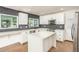 Modern kitchen with white cabinets, gray backsplash, stainless steel appliances, and an island at 4729 N 24Th St, Phoenix, AZ 85016