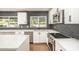 Well-lit kitchen showcasing white cabinetry, stainless steel appliances, dark backsplash, and a central island at 4729 N 24Th St, Phoenix, AZ 85016