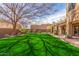 Large backyard with manicured lawn, mature landscaping and a view of the covered patio at 4937 W Desert Hollow Dr, Phoenix, AZ 85083