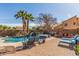 Charming backyard featuring a custom pool with a stone fireplace, palm trees and ample seating at 4937 W Desert Hollow Dr, Phoenix, AZ 85083