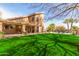 Expansive backyard featuring a large lawn, covered patio and comfortable outdoor seating at 4937 W Desert Hollow Dr, Phoenix, AZ 85083