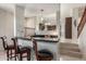Wet bar area featuring a black countertop, seating, cabinets and open view of the kitchen at 4937 W Desert Hollow Dr, Phoenix, AZ 85083