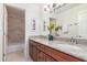 Bathroom with dual sinks, granite countertops, and tiled shower and tub at 4937 W Desert Hollow Dr, Phoenix, AZ 85083