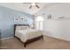 Bright bedroom featuring carpet, ceiling fan, a window, and blue accent wall at 4937 W Desert Hollow Dr, Phoenix, AZ 85083