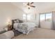 Inviting bedroom featuring soft carpet, ceiling fan, natural light, and a cozy seating area at 4937 W Desert Hollow Dr, Phoenix, AZ 85083
