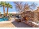 A stone fireplace sits next to a custom pool in this backyard, featuring stone masonry at 4937 W Desert Hollow Dr, Phoenix, AZ 85083