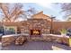Backyard stone fireplace with wooden storage that is next to a built in BBQ, ideal for outdoor entertaining at 4937 W Desert Hollow Dr, Phoenix, AZ 85083