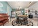 Inviting living room with travertine floors, piano, chandelier, and stylish furniture creating a cozy atmosphere at 4937 W Desert Hollow Dr, Phoenix, AZ 85083