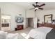 Bright and spacious main bedroom featuring a ceiling fan, TV, and adjoining bathroom entrance at 4937 W Desert Hollow Dr, Phoenix, AZ 85083
