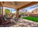 Inviting covered patio with brick flooring, ceiling fan, and comfortable seating, perfect for outdoor relaxation at 4937 W Desert Hollow Dr, Phoenix, AZ 85083