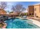 Beautiful pool area featuring a rock waterfall, lounge chairs, lush landscaping, and privacy fencing at 4937 W Desert Hollow Dr, Phoenix, AZ 85083