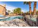Backyard pool and spa area with palm trees, rock features, and lounge chairs at 4937 W Desert Hollow Dr, Phoenix, AZ 85083