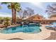 Beautiful backyard pool with waterfall feature, surrounded by lush landscaping and palm trees for a tropical feel at 4937 W Desert Hollow Dr, Phoenix, AZ 85083