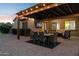 A covered patio with a dining set and comfortable seating, perfect for entertaining or relaxing outdoors at 5225 S Opal Pl, Chandler, AZ 85249