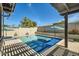 Sparkling blue swimming pool with patio umbrella surrounded by brick patio at 5225 S Opal Pl, Chandler, AZ 85249