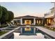 Luxury backyard featuring a pool reflecting the house, lush greenery, and elegant outdoor furniture at 5915 E Calle Del Sud --, Phoenix, AZ 85018