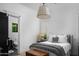 Bright bedroom featuring a stylish bed, wood chest and modern pendant lighting at 5915 E Calle Del Sud --, Phoenix, AZ 85018