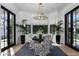 Sunlit dining area featuring large windows, elegant chairs, a stylish table, and lush greenery at 5915 E Calle Del Sud --, Phoenix, AZ 85018