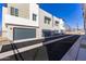 Modern townhome exterior featuring gray garages under a bright blue sky at 651 N Ironwood Dr # 2, Apache Junction, AZ 85120